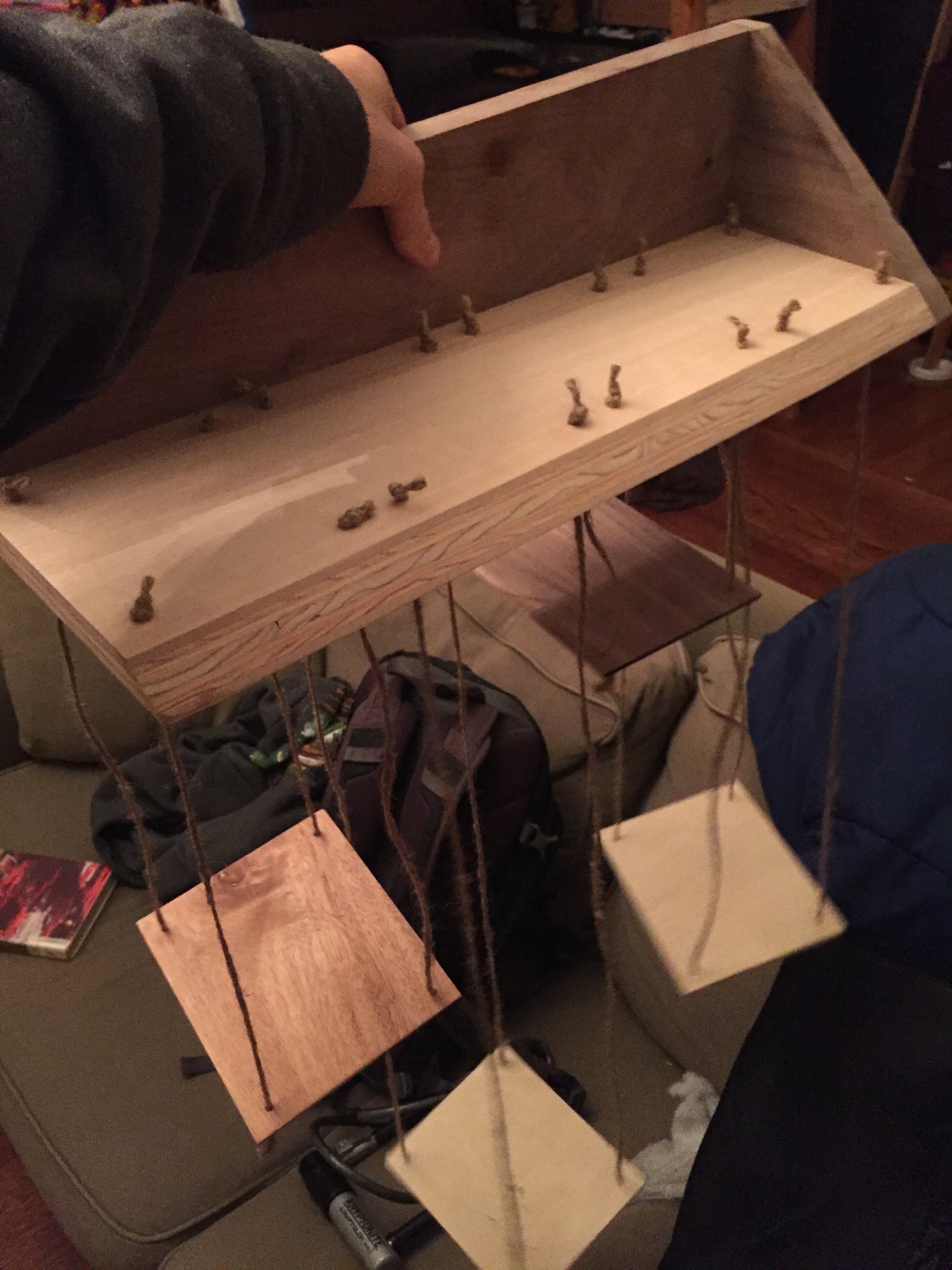 Thomas holding a wall-mounted series of hanging planter platforms.